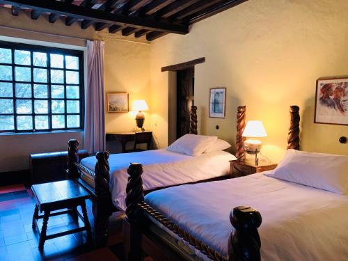 a bedroom with two beds and a window at Hotel Museo Mayan Inn in Chichicastenango