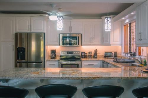 a kitchen with white cabinets and a large marble counter top at Bahia Pez Vela Resort in Ocotal