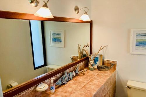 a bathroom with a large mirror and a sink at Bahia Pez Vela Resort in Ocotal