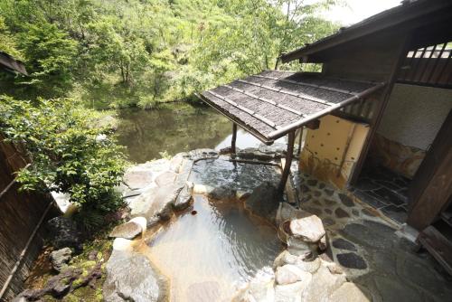 a pool of water with a wooden table in front of a house at Hozantei in Minamioguni