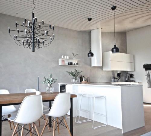 a kitchen with a dining table and white chairs at Arctic Riverside Villa in Rovaniemi