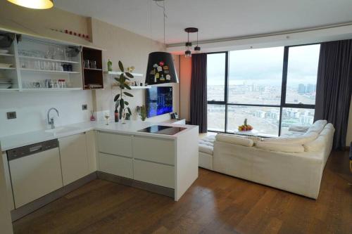 una cocina con fregadero y un sofá en una habitación con ventanas en Lux Residance 40th floor, sound system, 65 inch TV en Ankara