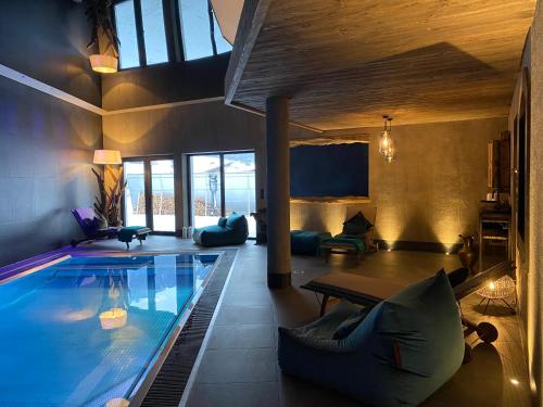 una gran piscina en una casa con sala de estar en Villa22 Oetz en Oetz