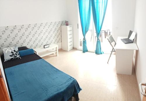 a bedroom with a bed and a desk with a laptop at Casa Analiz in Arrecife