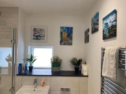 a bathroom with a sink and a window at Exquisite & Contemporary 2 Bed Apartment w Parking 10 mins walk to Papworth, Addenbrookes hospitals & Bio Medical Campus in Trumpington