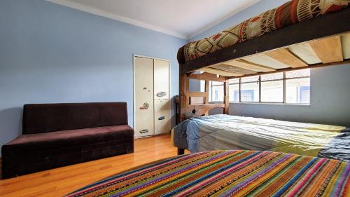 a bedroom with a bunk bed and a chair at Inka City Hostel in Cusco