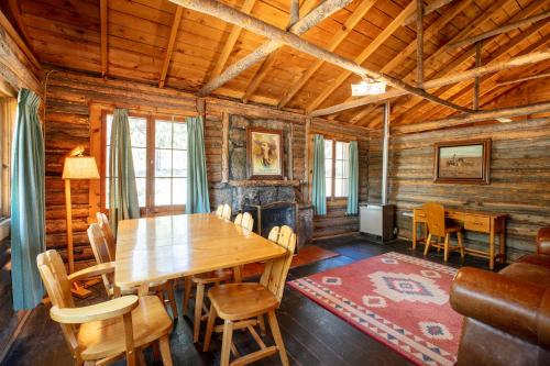 a dining room with a wooden table and a fireplace at The Meeker Park Lodge in Allenspark