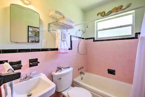 a pink bathroom with a sink and a toilet at Cozy NSB Abode with BBQ and Fire Pit - Walk to Beach! in New Smyrna Beach