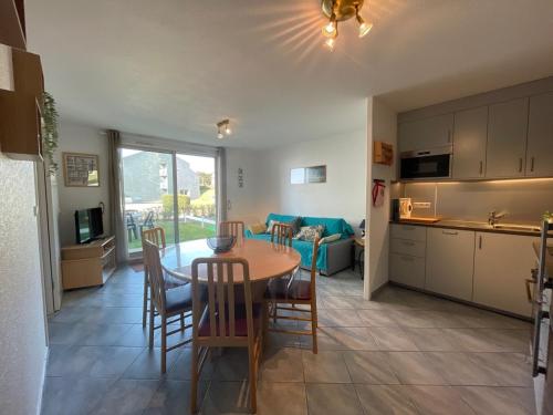 une cuisine et un salon avec une table et des chaises dans l'établissement Appartement à 50m plage avec terrasse et jardin - FR-1-361-14, à Jullouville