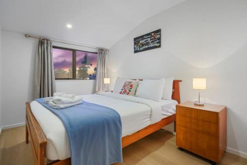 Un dormitorio con una cama grande y una ventana en 3 Bdrm Mangere Delight - Parking - Wi-Fi - Netflix, en Auckland