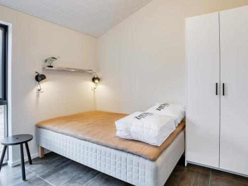 a bedroom with a bed with white walls at 8 person holiday home in Læsø-By Traum in Læsø