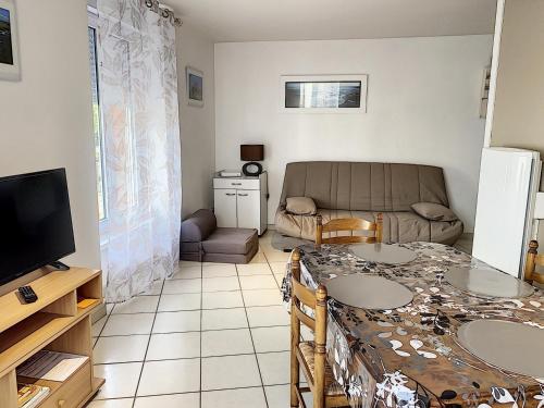 un salon avec une table et un canapé dans l'établissement Studio à deux pas de la plage, proche commerces avec Wifi et équipements complets - FR-1-361-40, à Saint-Pair-sur-Mer