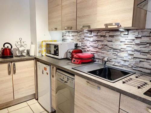 a kitchen with a sink and a microwave at Studio à deux pas de la plage, proche commerces avec Wifi et équipements complets - FR-1-361-40 in Saint-Pair-sur-Mer