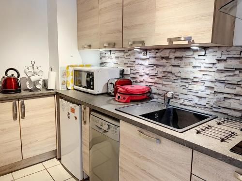 a kitchen with a sink and a microwave at Appartement Saint-Pair-sur-Mer, 1 pièce, 2 personnes - FR-1-361-40 in Saint-Pair-sur-Mer