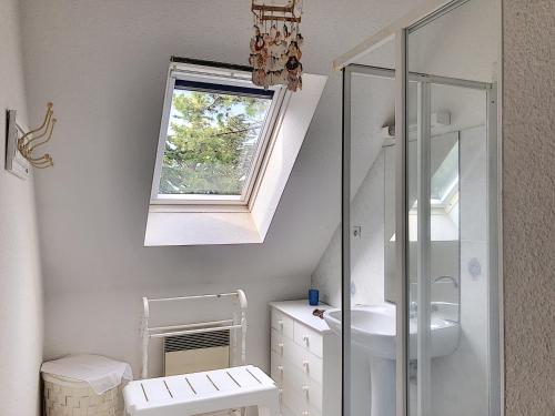 uma casa de banho branca com um lavatório e um espelho em Maison Jullouville, 4 pièces, 6 personnes - FR-1-361-57 em Jullouville-les-Pins