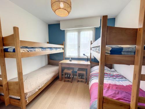 - une chambre avec 3 lits superposés et un bureau dans l'établissement Appartement en bord de mer avec terrasse et parking - FR-1-361-85, à Jullouville