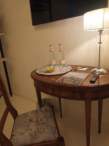 a table with two bottles and a plate with wine glasses at "A casa di Giacomo" Luxury Rooms con aria condizionata in Bergamo
