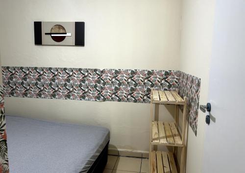 a small bedroom with a bed and a wall at WR7 Hostel in São Bernardo do Campo