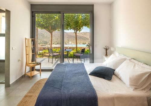 a bedroom with a bed and a view of a patio at Haven Villa in Ierápetra