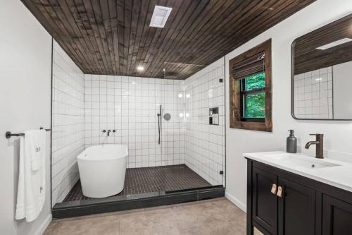 a bathroom with a tub and a shower and a sink at Campfire Bungalow - Kid Friendly in Palenville