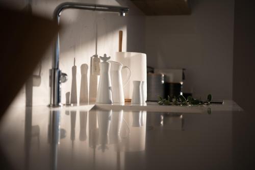 a kitchen counter with white utensils on a wall at Haven Villa in Ierápetra