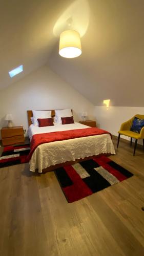 a bedroom with a large bed with a red blanket at Cozy 1 BR w/ balcony, ocean view & perfect sunsets in Ribeira Brava