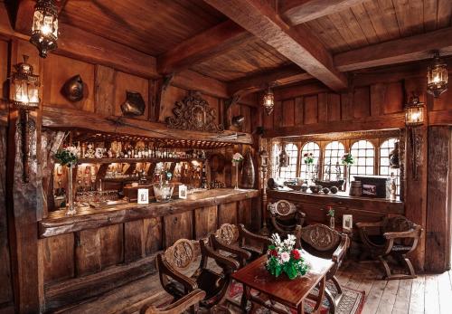Belleek Castle, Ballina في بالينا: بار في غرفة مع جدران وكراسي خشبية
