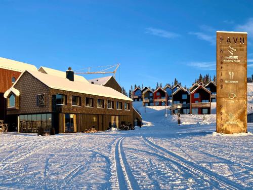 eine Ski-Lodge mit einem Schild im Schnee in der Unterkunft New ski in-out apartment with sauna in Hafjell in Øyer