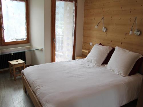 une chambre avec un grand lit blanc avec deux oreillers dans l'établissement Appartement rénové 2 chambres, centre station, WIFI - FR-1-459-69, à La Clusaz
