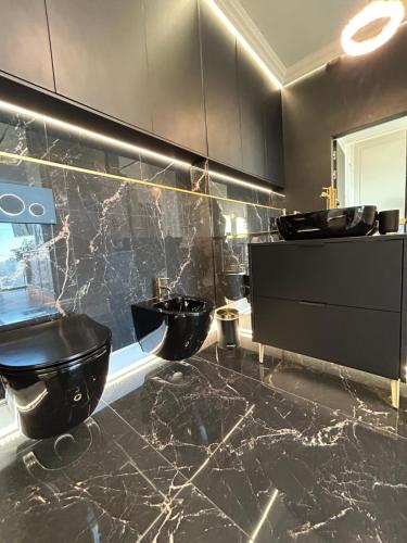 a bathroom with two sinks and two toilets at Hanza Tower HOME4U in Szczecin