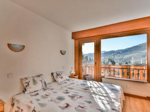 une chambre avec un lit et une grande fenêtre dans l'établissement Charmant T2 aux Gets - Proche Pistes et Centre - 4 pers - FR-1-685-61, aux Gets