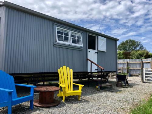 ein winziges Haus mit bunten Stühlen und einem Tisch in der Unterkunft The Shepherd's Rest in Oamaru