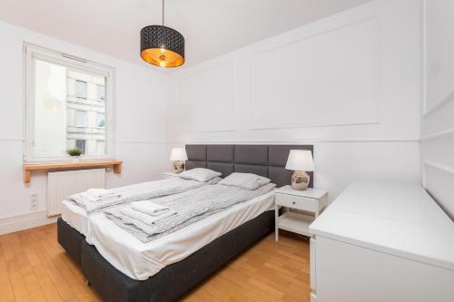 ein weißes Schlafzimmer mit einem großen Bett und einem Fenster in der Unterkunft Apartament Polna by Your Freedom in Warschau