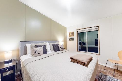 Un dormitorio blanco con una cama grande y una ventana en BLK Beach House, en Florence