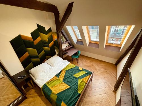 a bedroom with a bed and two windows at Long Attic Studio in Poznań