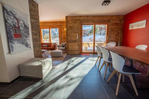 un salon avec une table et des chaises en bois dans l'établissement Chalet de l'Olympe A2, à Les Allues