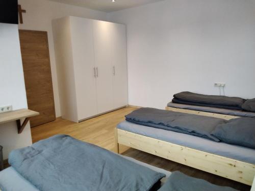 a bedroom with two beds and a white cabinet at Zum Schulhaus in Burglengenfeld