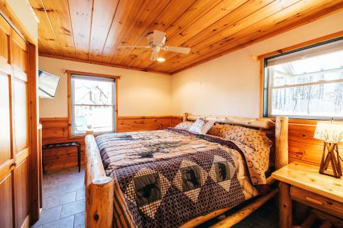 a bedroom with a bed and a wooden ceiling at Ski Chalet w-Hot Tub, Only 3 min to Sunday River ski lifts! in Bethel