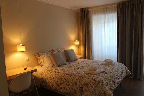 a bedroom with a bed with two stuffed animals on it at Cerveira House in Vila Nova de Cerveira