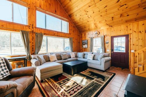a living room with a couch and a table at Ski Chalet w-Hot Tub, Only 3 min to Sunday River ski lifts! in Bethel