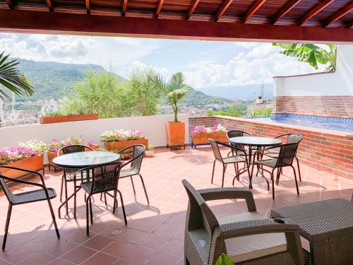 un patio con mesas y sillas y vistas. en Hotel Santorini, en San Gil