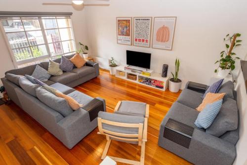 a living room with two couches and a television at Brunswick 3bdrm townhouse, with parking by Custom Bnb Hosting in Melbourne
