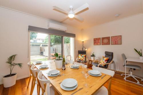 a dining room with a wooden table and chairs at Brunswick 3bdrm townhouse, with parking by Custom Bnb Hosting in Melbourne