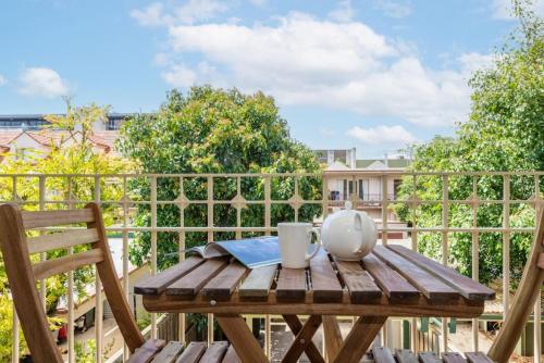 a wooden table and chairs on a balcony at Brunswick 3bdrm townhouse, with parking by Custom Bnb Hosting in Melbourne