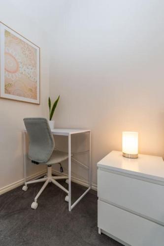 an office with a desk and a chair and a lamp at Brunswick 3bdrm townhouse, with parking by Custom Bnb Hosting in Melbourne