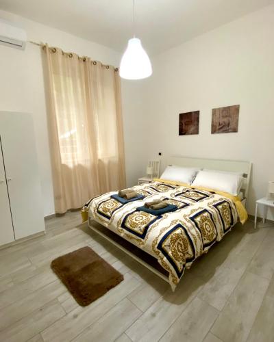 a bedroom with a bed with a comforter on it at Villa Elisa in Minturno