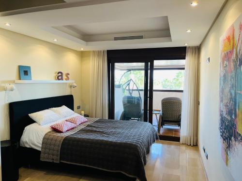 a bedroom with a bed and a balcony at Bahia De La Plata 1A in Estepona