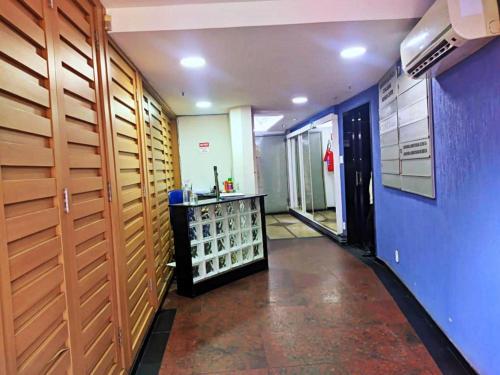 a long hallway with a blue wall and a room with a counter at Hostel Princess Copacabana in Rio de Janeiro
