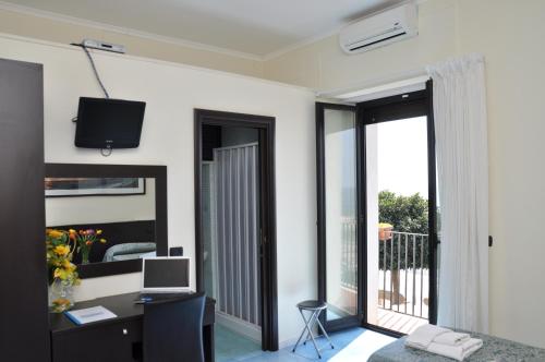 a living room with a desk and a tv on the wall at B&B Stella Maris in Diamante