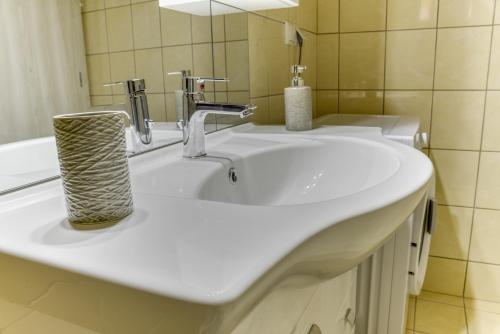 a bathroom with a white sink and a mirror at ΔΙΑΜΈΡΙΣΜΑ ΜΕΝΤΗΣ in Igoumenitsa